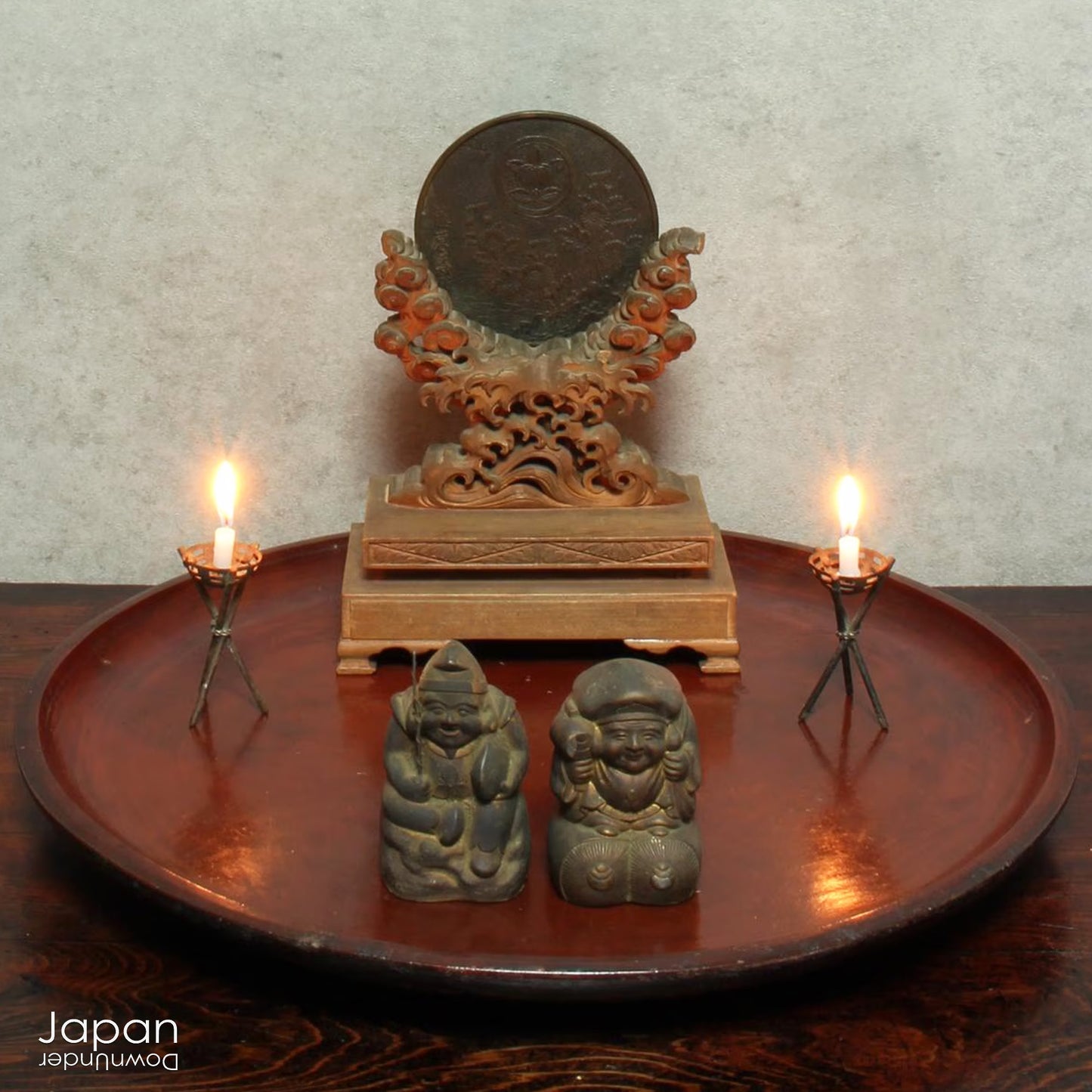 Discover an extraordinary piece of history with this stunning, one-of-a-kind Shinto shrine mirror from the Edo period. This rare treasure, displayed on an exquisitely carved wooden stand, beautifully merges history, spirituality, and artistry. The piece is complete with delicate metal candle holders, making it a perfect addition to any collection or spiritual space.