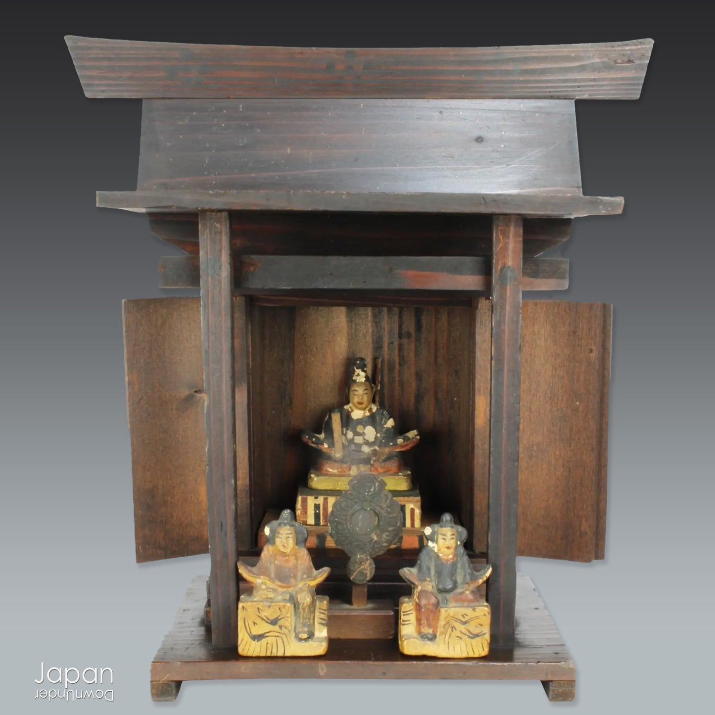 A perfect addition to your spiritual space, this quaint rustic antique Shinto shrine, made to be placed on the kamidana (god shelf), houses the lucky god Tenjin, protected by his guards. The charming hand crafted god house embodies the essence of Shinto folk faith.